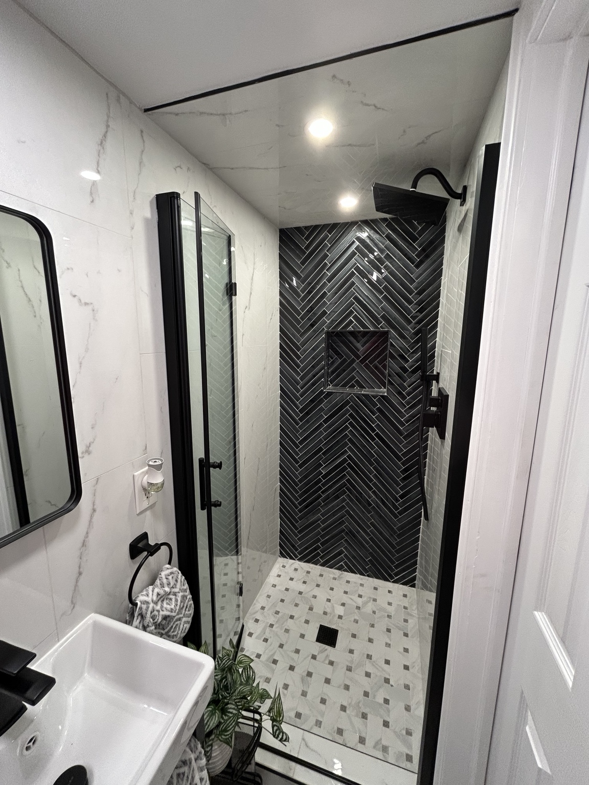 Finished bathroom with black herringbone shower tile